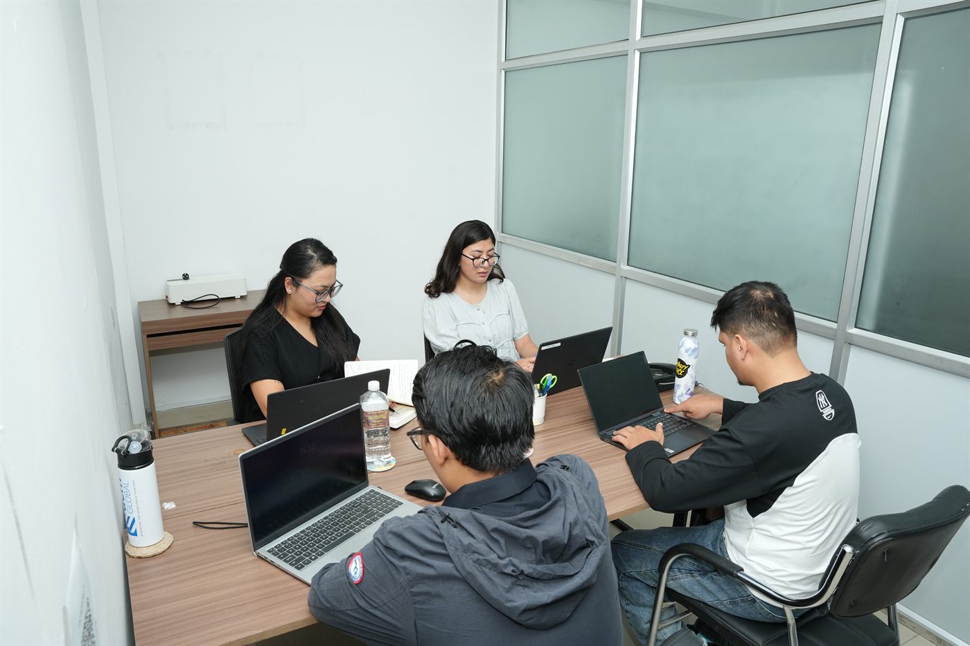 A team of five working around the table in the Begnas cabin at Stratex