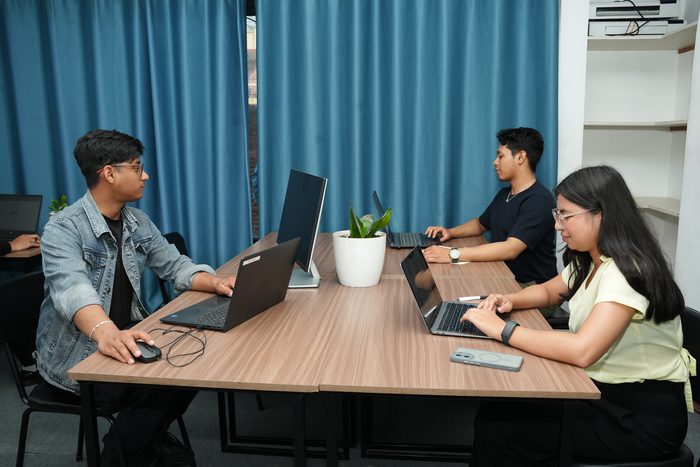 Four members working around the shared table on the open third floor at Stratex
