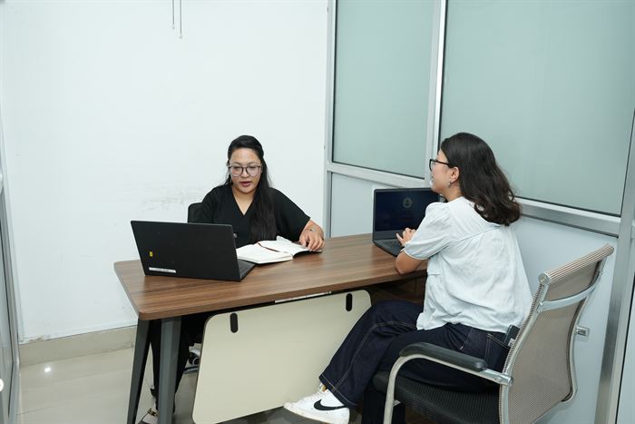 Two members in discussion at the desk in the Fewa cabin at Stratex