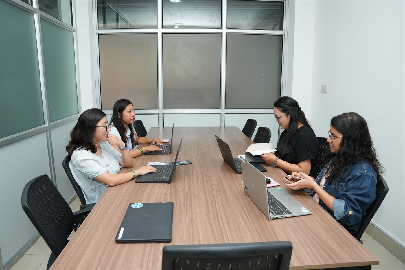 Members working along the long table in the Gosaikunda team cabin at Stratex