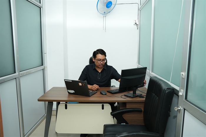 A member at the desk in the Rara private cabin at Stratex
