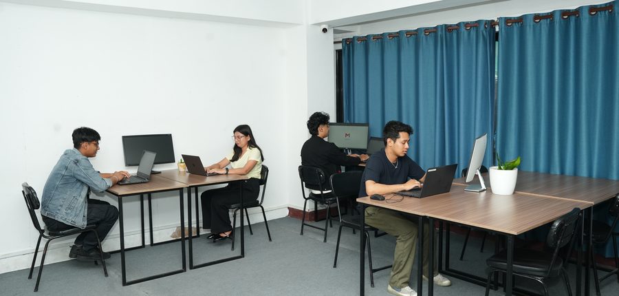 Members working at dedicated desks on the open third floor at Stratex Co Working Space